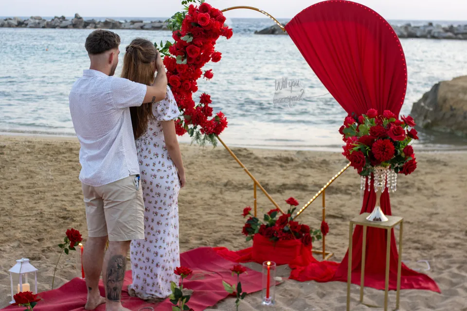 Proposal set up with red roses on the beach