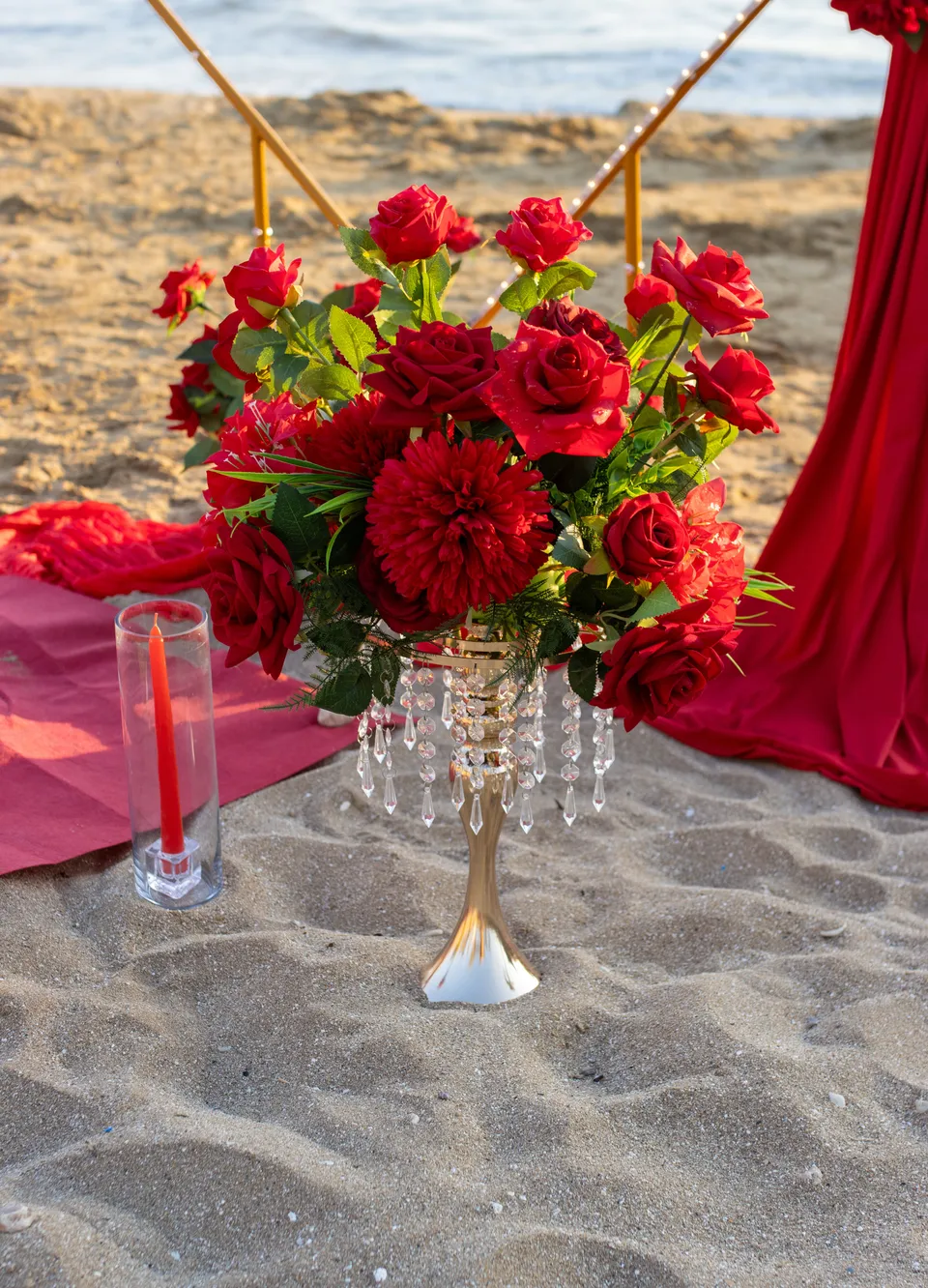 Red roses and candles in the sand