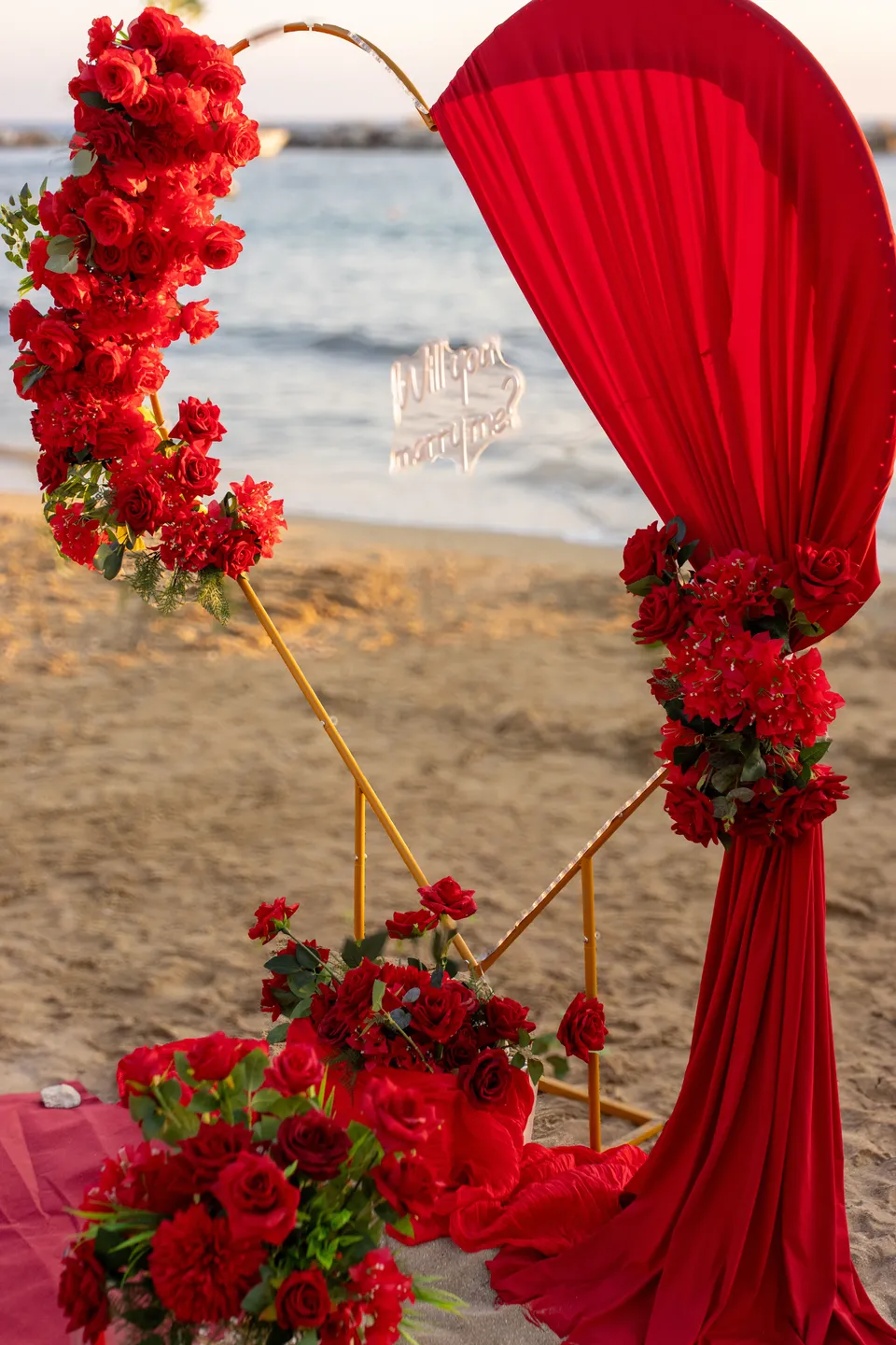 Red draped arch on the beach