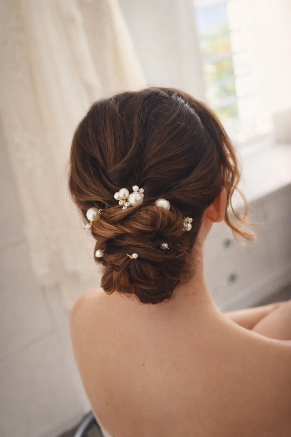 Romantic low chignon with pearl pins