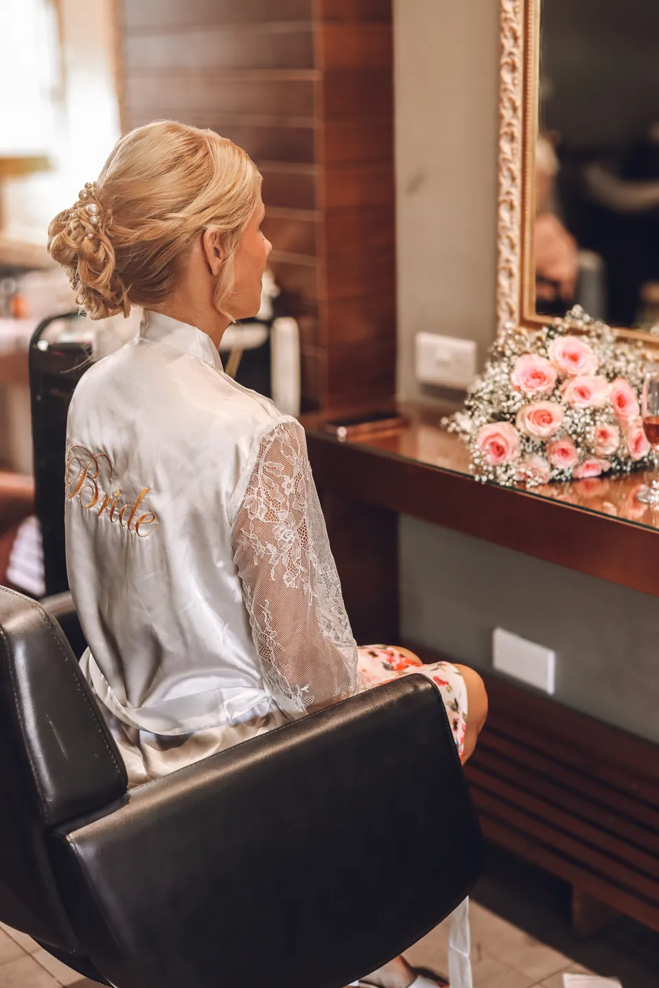 Bride in a satin robe in the salon chair