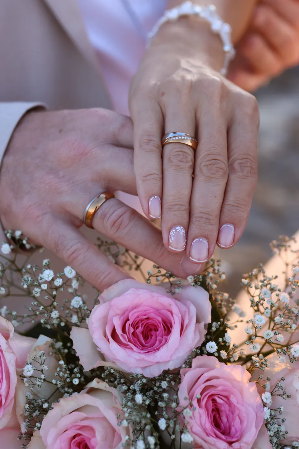 Wedding rings and pink roses